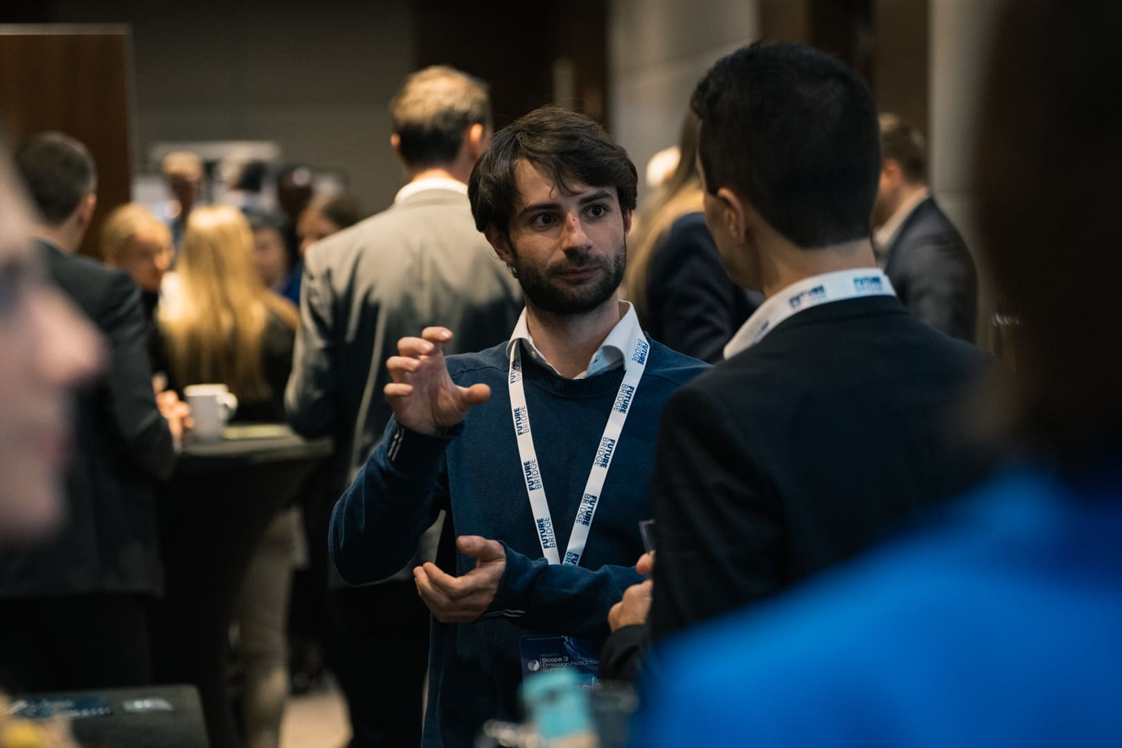 Two delegates exchanging contact details during a networking break at a Future Bridge summit